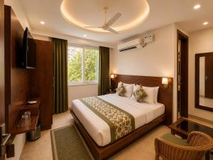 a hotel room with a bed and a television at Sitara Premium Dhakad Gold, Near Lakshman Jhula, Tapovan in Rishīkesh