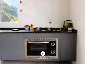 a microwave oven in a kitchen with a counter at Refugio Marincek - Gonçalves - MG in Gonçalves