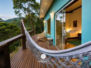 a hammock on the deck of a house at Refugio Marincek - Gonçalves - MG in Gonçalves