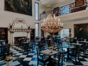 a dining room with tables and chairs and a chandelier at Hotel Castelo Nacional Inn Campos do Jordão in Campos do Jordão