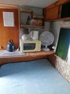 a small kitchen with a microwave and a microwave at Caravane au bord de la rivière in Saint-Corneille