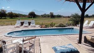 a swimming pool with chairs and a table at Atacama Loft & Glamp in San Pedro de Atacama +57 photos