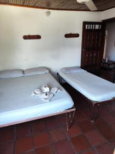 two beds with towels on them in a room at Hotel Cacique in Socorro