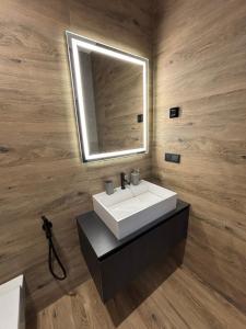 a bathroom with a white sink and a mirror at Bavaro apartments 8 in Ivano-Frankivsk +6 photos