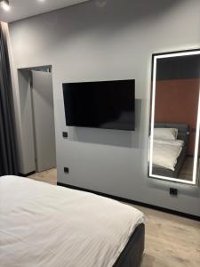 a bedroom with a flat screen tv and a bed at Bavaro apartments 8 in Ivano-Frankivsk