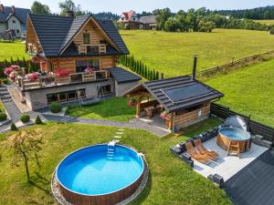 an aerial view of a log home with a pool at Domek DeLuxe Spa z sauną i jacuzzi- Nowy Targ blisko Zakopanego i Białki Tatrzańskiej in Nowy Targ
