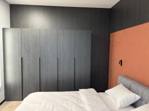 a bedroom with a white bed and a black wall at Bavaro apartments 8 in Ivano-Frankivsk