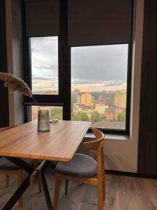 a wooden table with a chair and a window at Bavaro apartments 8 in Ivano-Frankivsk