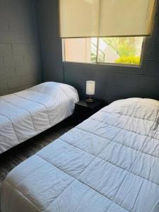 a bedroom with two beds and a window at Refugio las pircas in Vicuña +4 photos