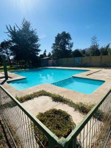 a swimming pool with a fence around it at Refugio las pircas in Vicuña