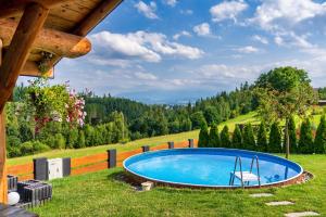 a swimming pool in the middle of a grassy field at Domek DeLuxe Spa z sauną i jacuzzi- Nowy Targ blisko Zakopanego i Białki Tatrzańskiej in Nowy Targ +78 photos