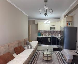 a living room with a couch and a kitchen at REA Apartment in Shkodër +18 photos