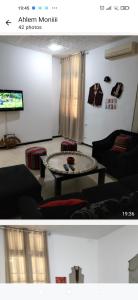 a living room with a table and a tv at Relax in Tunis