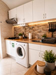 a kitchen with a washing machine and a sink at Casa do Arco II in Évora