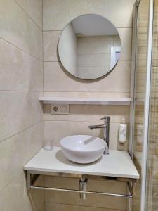 a bathroom with a white sink and a mirror at Alojamiento cruceiro Arans in La Cañiza