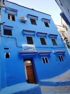 a blue building with a door in front of it at FATI GUEST HOUSe in Chefchaouen