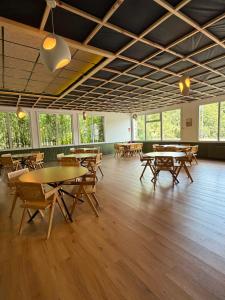 a large room with tables and chairs and windows at Dos Romeiros in Palas de Rei