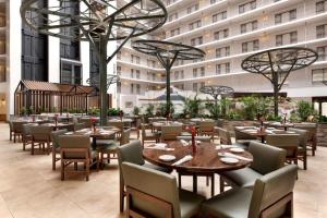 a restaurant with tables and chairs and a building at The Signature Suites in Irving