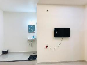 a room with a tv on a wall with a sink at Balaji Lodge in Laling
