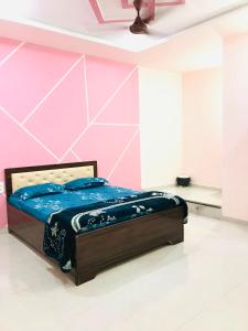a bed in a room with a pink wall at Balaji Lodge in Laling +4 photos