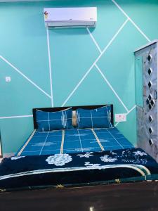 a bed in a room with a blue wall at Balaji Lodge in Laling