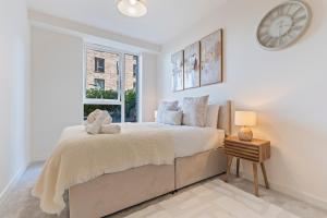a bedroom with a bed with a clock on the wall at 2 Bed Flat, Pool Table, Terrace 4 stops to Wembley in Hatch End