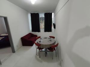 a room with a table and chairs and a couch at Apartamento na RETA de Teresópolis in Teresópolis +25 photos