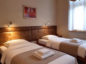 a bedroom with two beds with towels on them at Kazimierz Secret in Krakow