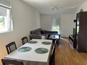 a living room with a table and a couch at Apartman VUKOVIĆ in Žabljak +3 photos