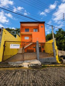 an orange and yellow building with a gate at Aura de Cunha in Cunha