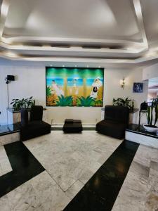 a lobby with two couches and a large painting on the wall at Fiesta Inn Xalapa in Xalapa