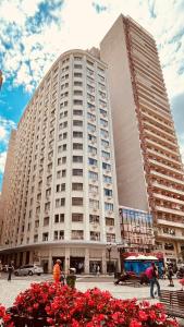 a large white building with red flowers in front of it at Hotel Del Rey by Poty - RUA XV DE NOVEMBRO in Curitiba