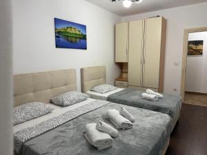 two beds sitting next to each other in a bedroom at REA Apartment in Shkodër