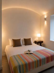 a bedroom with a bed with a book on it at Casinha do Pão Bolorento in Évora