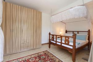 a bedroom with a canopy bed and a rug at Diani Luxe Villa 1bdr A, 600m from the beach in Galu