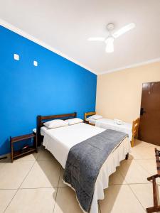 two beds in a room with a blue wall at Aura de Cunha in Cunha