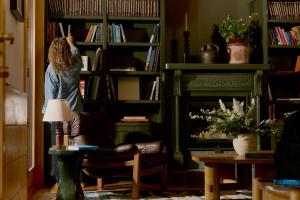 a woman standing in front of a book shelf at The Alpine House in Jackson
