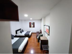 a living room with a bed and a couch at Hotel macao colombia in Bogotá