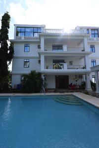 a house with a swimming pool in front of a building at Diani Luxe Villa 1bdr A, 600m from the beach in Galu +5 photos