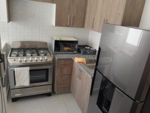 a kitchen with a stainless steel stove and a refrigerator at Rinconcito Caribeno Apartment in San Pedro de Macorís +4 photos