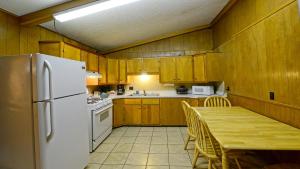 a kitchen with a table and a white refrigerator at Arrowhead 04 in Red River
