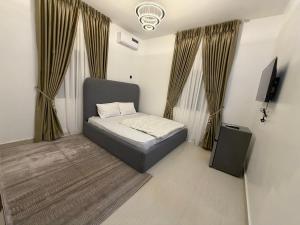a small bedroom with a bed and a television at Was Homes in Abuja