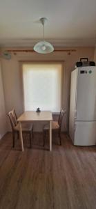 a dining room with a table and a refrigerator at Elva südalinna kodumajutus in Elva