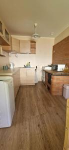 a kitchen with white appliances and a wooden floor at Elva südalinna kodumajutus in Elva