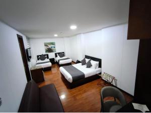 a hotel room with two beds and a couch at Hotel macao colombia in Bogotá +31 photos