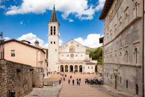 a large building with a clock tower in a street at Augusta e Libero Apartments in Spoleto
