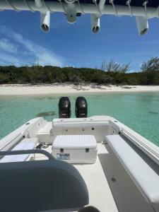 two people sitting on the back of a boat in the ocean at 4 Island Boat Tour in Nassau