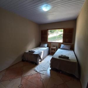 a bedroom with two beds and a window at Pousada Santa Rita in Ouro Preto