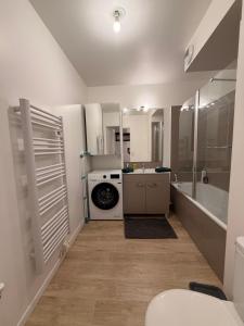 a bathroom with a sink and a washing machine at Cocon avec petit jardin centre Bondy in Bondy +10 photos