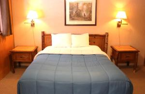 a bed in a hotel room with two tables at Arrowhead 02 in Red River